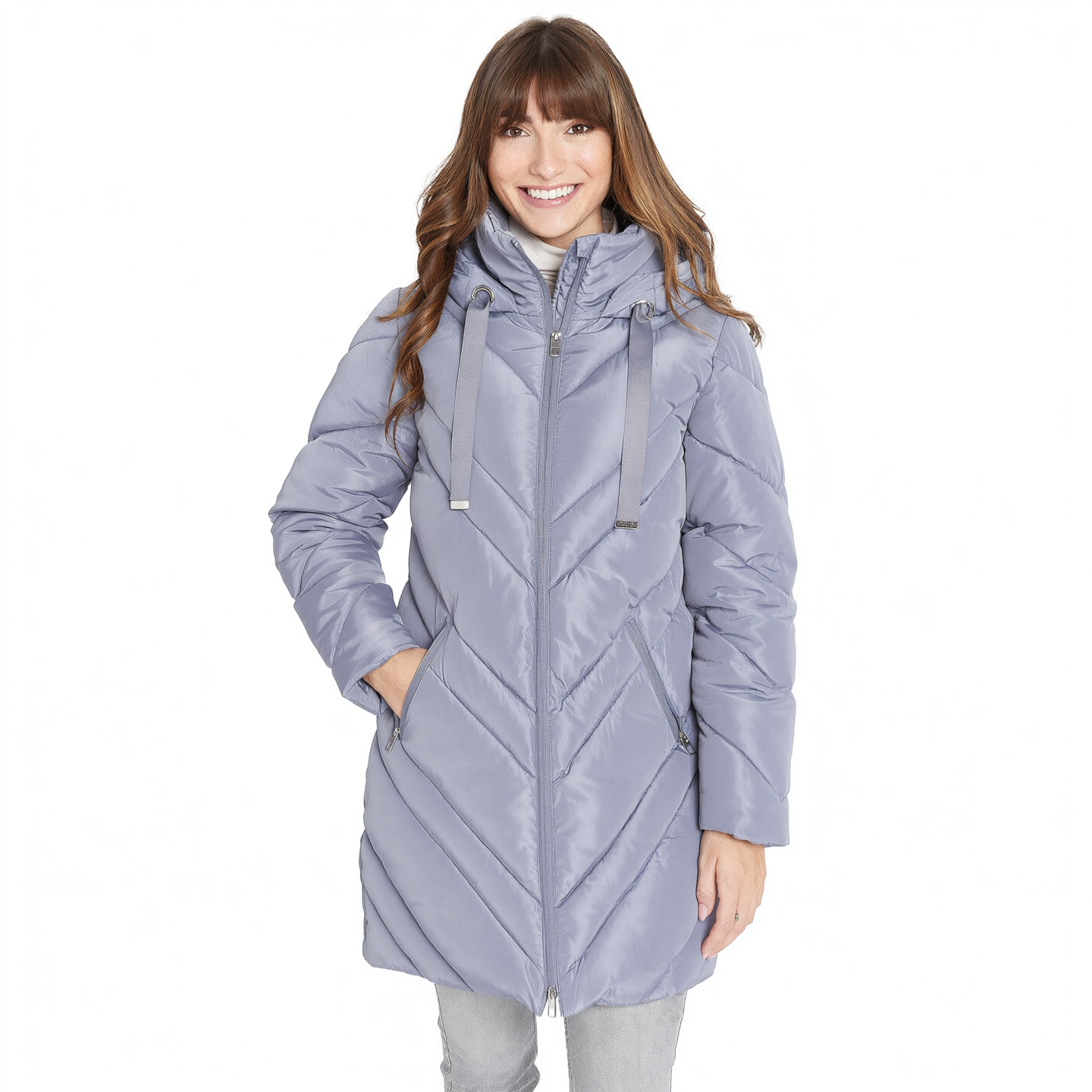 A woman wearing a light lavender-gray hooded puffer jacket with a chevron quilted pattern, standing against a plain white background.