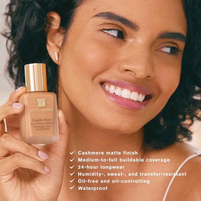 Woman holding Estée Lauder foundation bottle with product features listed.