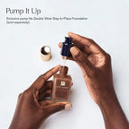 Estée Lauder foundation bottle with pump being used, on a light background