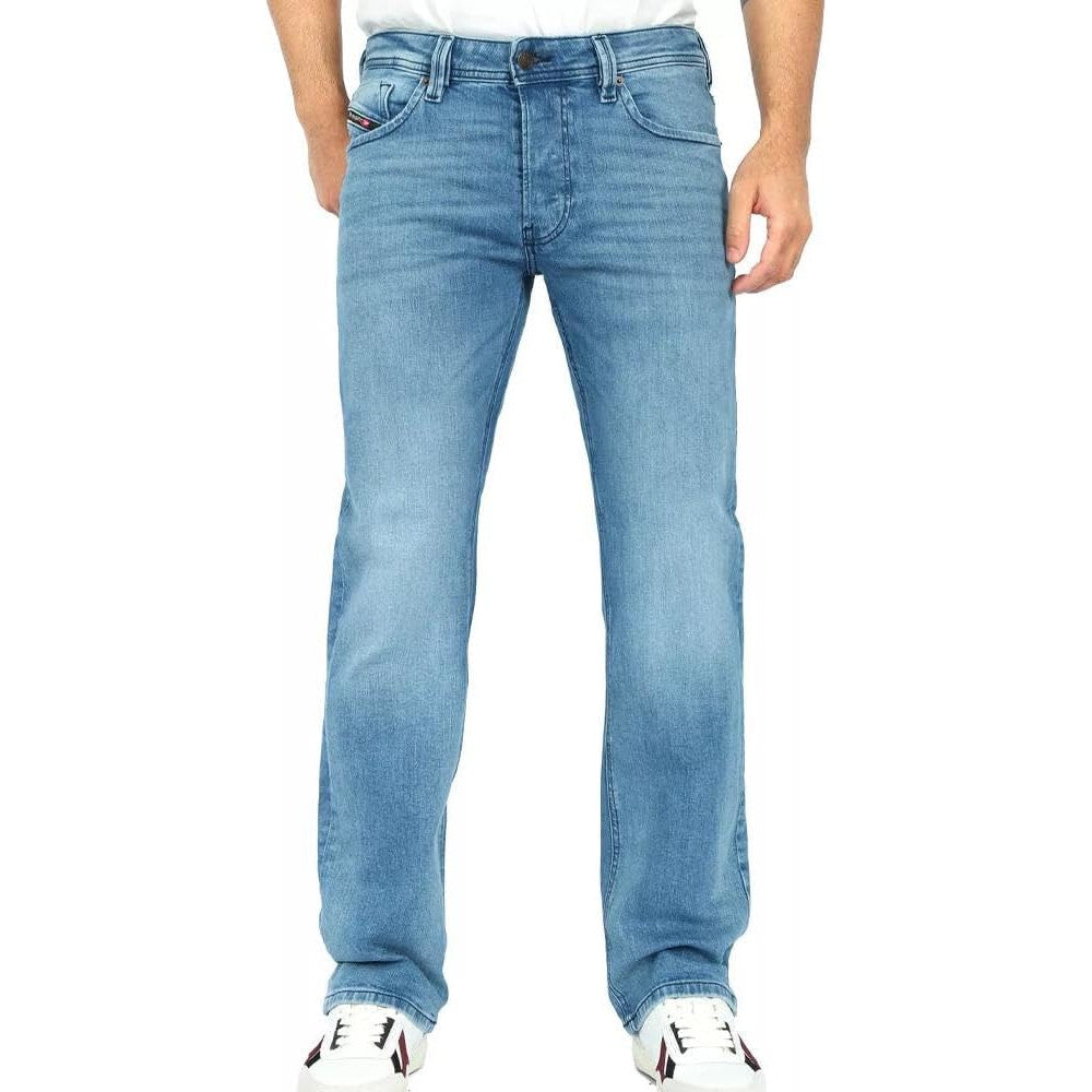 A person wearing light blue denim jeans with a white t-shirt and white sneakers, shown from the waist down against a plain white background.